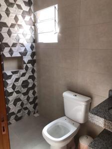 若阿诺波利斯Quiosque 2的一间带白色卫生间的浴室和窗户。