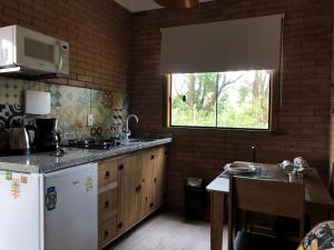 因比图巴Moradas Brisa da Lagoa的厨房配有白色冰箱和窗户。