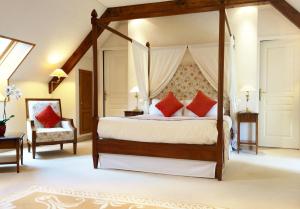 滨海莫厄朗科塔格庄园酒店的一间卧室配有一张带红色枕头的天蓬床