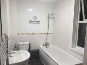 巴尔内特Lovely 1 bedroom flat High Barnet 3 mins away的带浴缸、卫生间和盥洗盆的浴室