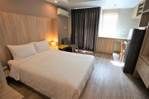 曼谷班坦瓦公寓 - 拉察达皮瑟克地铁站的酒店客房设有白色的床和窗户。