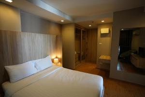 曼谷班坦瓦公寓 - 拉察达皮瑟克地铁站的一间带白色床的卧室和一间浴室