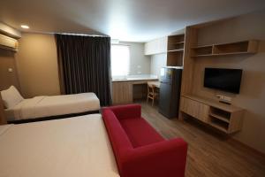 曼谷班坦瓦公寓 - 拉察达皮瑟克地铁站的酒店客房,配有一张床和一张红色椅子