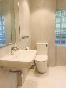 奥克兰海滩山林小屋公寓的白色的浴室设有水槽和卫生间。