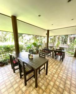 考索Khaosok Good view Resort - SHA PLUS的铺有瓷砖地板,设有带桌椅的庭院。