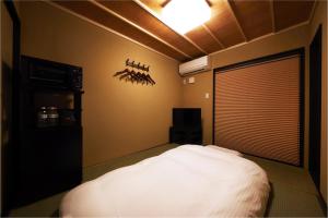 京都Rinn Hanayacho Asagiri的一间卧室设有一张床、一台电视和天花板