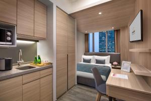香港香港亚士厘名致公寓酒店的酒店客房配有一张床、一个水槽和一张书桌