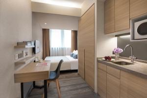 香港香港亚士厘名致公寓酒店的酒店客房配有一张床和一间带书桌的厨房