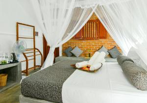康提Thotupola Residence的一间卧室配有白色窗帘的床