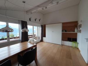 埃梅滕Elfe - Apartments Studio apartment for 2-4 guests with panorama view的一间带木桌和椅子的用餐室