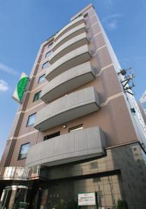仙台绿色标志酒店的一座高大的建筑,旁边有一个标志