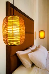 乔治市任伊唐文化酒店的一间卧室配有带两个枕头和一盏灯的床