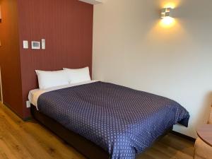 那霸Clean Hotels in Higashimachi的一间卧室配有一张带蓝色毯子的床
