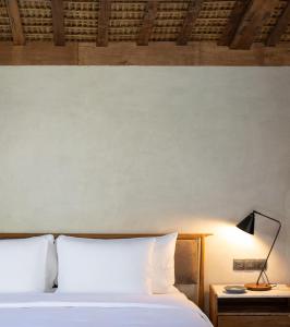 乌鲁瓦图The Asa Maia - Adults Only Resort的一间卧室配有一张床和一张桌子上的台灯