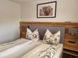 瓦格赖恩弗雷茨公寓的一张带枕头的床和一幅牛的照片