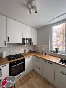 杜什尼基-兹德鲁伊Apartament Wspomnienie的厨房配有白色橱柜和炉灶烤箱。