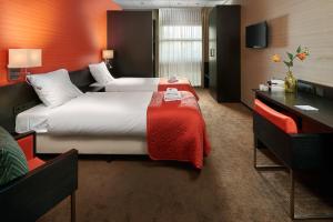 海尔许霍瓦德Hotel Babylon Heerhugowaard - Alkmaar的酒店客房配有两张床和一张书桌