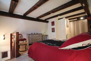 鲁法克Gîte de la Liberté的一间卧室配有红色的床和椅子