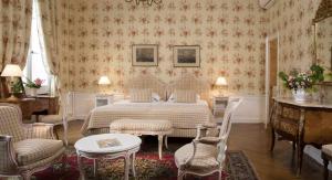 阿姆博斯舒瓦瑟尔酒店的一间卧室配有一张床、两把椅子和一张桌子