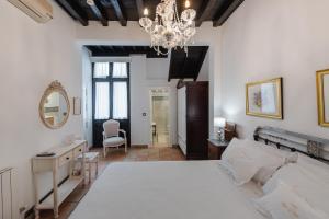 格拉纳达Hotel Rosa De oro的卧室配有一张白色大床和吊灯。