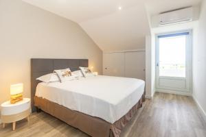 圣吉尔莱班Cap Noir - magnifique vue mer - St Gilles centre的卧室设有一张白色大床和一扇窗户。