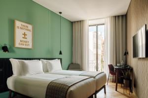 里斯本Hotel Hotel - Member of Design Hotels的酒店客房设有床和窗户。