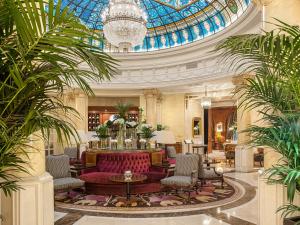 马德里Hotel Fenix Gran Meliá - The Leading Hotels of the World的大堂设有红色的沙发和玻璃天花板