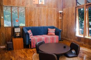 万隆萨玛米花园旅馆的客厅配有蓝色的沙发和桌子