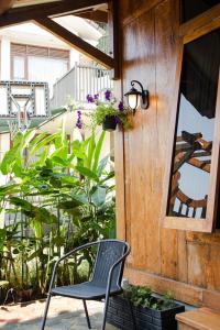 万隆萨玛米花园旅馆的一个带窗户和植物的庭院的椅子