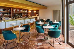 马尔切西内卡普里酒店的餐厅内带绿色桌椅的酒吧