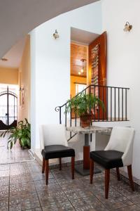 雅典Psyri Neoclassical House with Yard的走廊设有两把椅子和一张桌子,楼梯