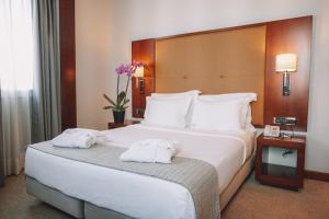 里斯本多姆卡洛斯自由酒店的酒店客房带一张大床,带毛巾
