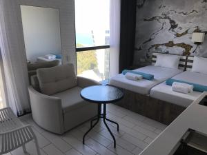 巴统Apartment In Porta Batumi Tower的客房设有两张床、椅子和桌子。