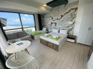 巴统Apartment In Porta Batumi Tower的酒店客房配有床、沙发和桌子。