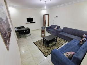 瓦迪穆萨Rakan ApartHotel and Luxury Rooms的客厅配有蓝色的沙发和桌子