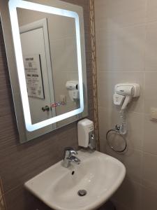 瓦尔纳Three Dolphins Family Hotel的浴室设有白色水槽和镜子