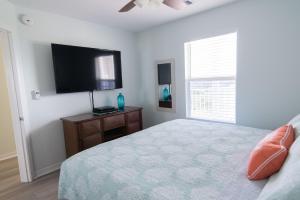 格尔夫海岸Grand Beach Resort Penthouse 1的一间卧室配有一张床和一台平面电视