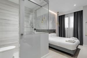 马德里EMBA ROOM的白色的浴室设有一张床和淋浴。