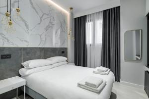 马德里EMBA ROOM的卧室配有白色床和毛巾