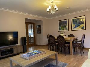 德里门Foxglove Cottages的客厅设有餐桌和电视