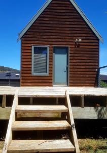 里士满Red Brier Cottage Accommodation的木屋前方设有大型木制甲板