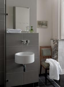马斯特里赫特Boutique Hotel Grote Gracht的浴室设有水槽、椅子和镜子