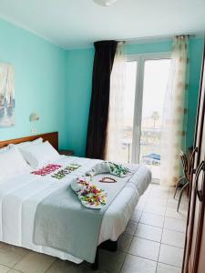里米尼Hotel Blue Moon的一间卧室,床上放着鲜花