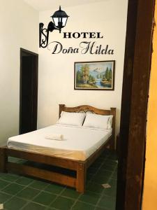 San MartínHotel Doña Hilda的一张床位,房间上标有读过Dolinulla酒店的标志