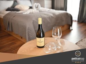 科帕奥尼克Apartman PETICA KOP A8 Kopaonik的一张桌子上坐着一瓶葡萄酒和一杯葡萄酒