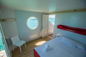 勒马兰Aqualodge Martinique的一间卧室设有一张床、一个窗口和一把椅子