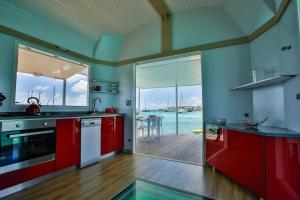 勒马兰Aqualodge Martinique的一间厨房,配有红色橱柜,享有水景