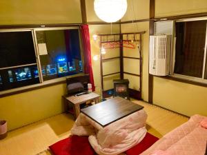 京都Benidaruma - Sakuramochi的客厅配有桌子、沙发和窗户。