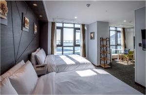 釜山Griffinbay Hotel的酒店客房设有两张床和一个阳台。