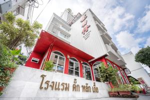 曼谷达叻仔精品酒店的一座红色的建筑,上面写着“火车上是懒人”的话
